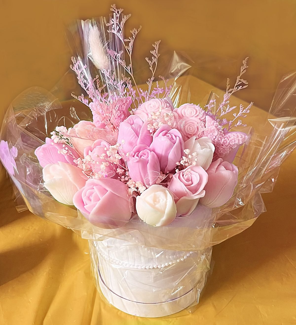 A Micro Meadow of pink and ivory soap roses, wrapped in clear cellophane